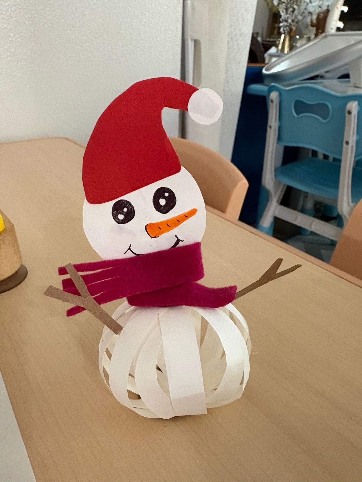 A snowman craft made from white paper and red felt