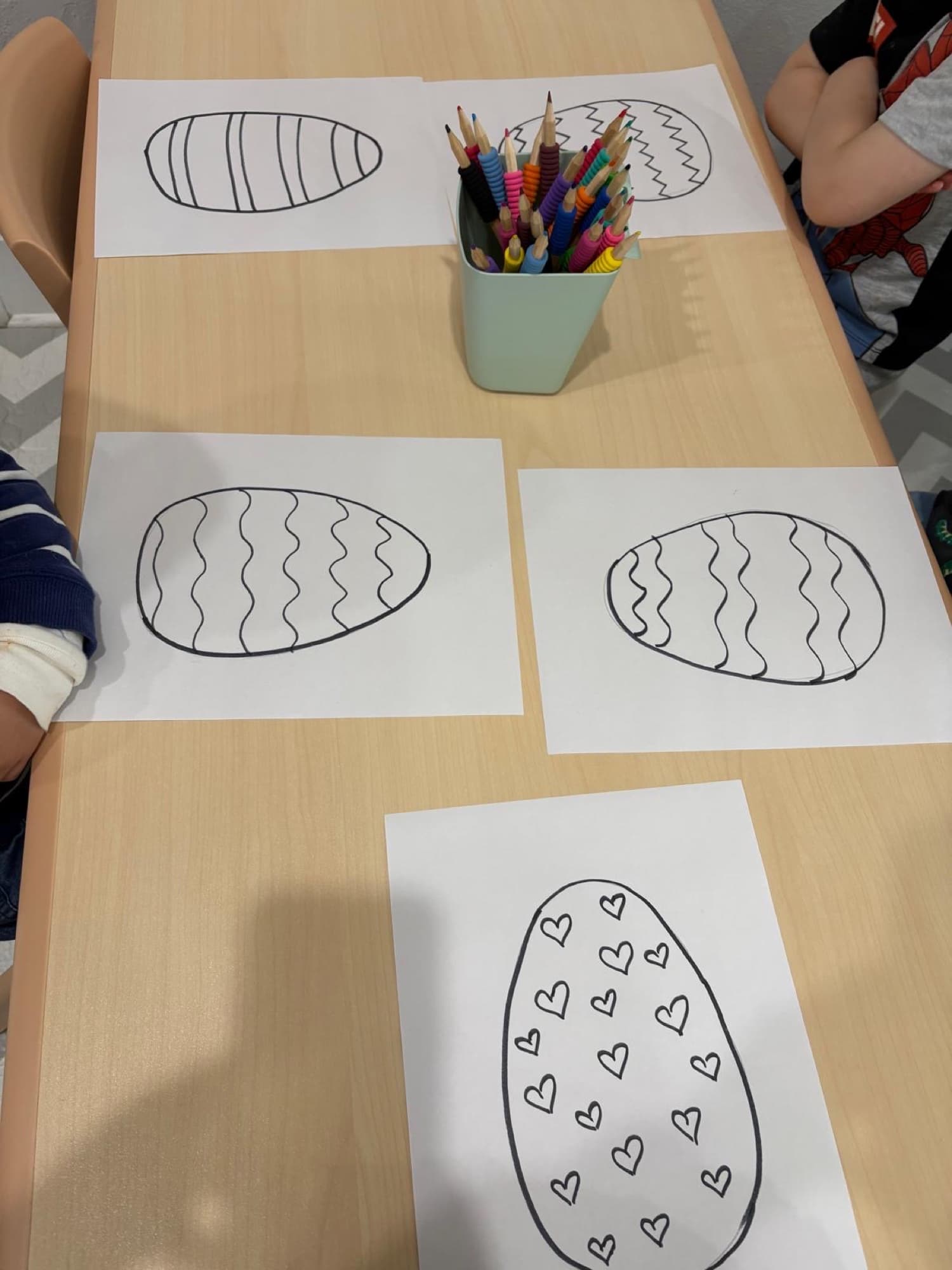 Easter egg coloring pages laid out at the art table