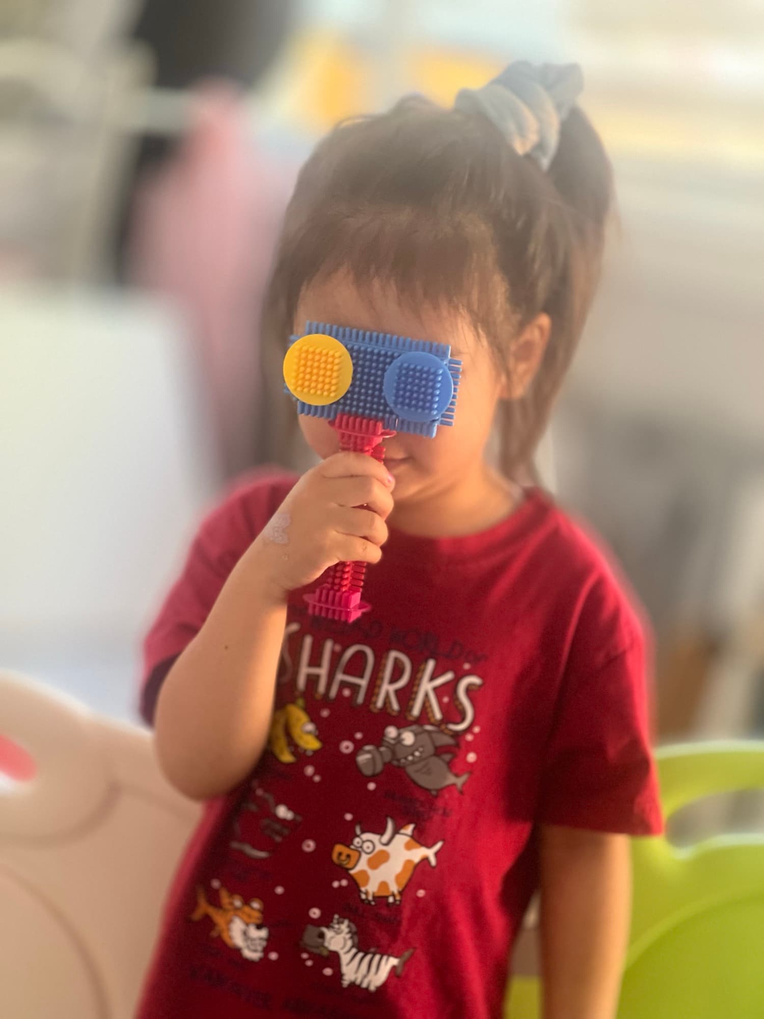 A young child exploring a colorful sensory toy